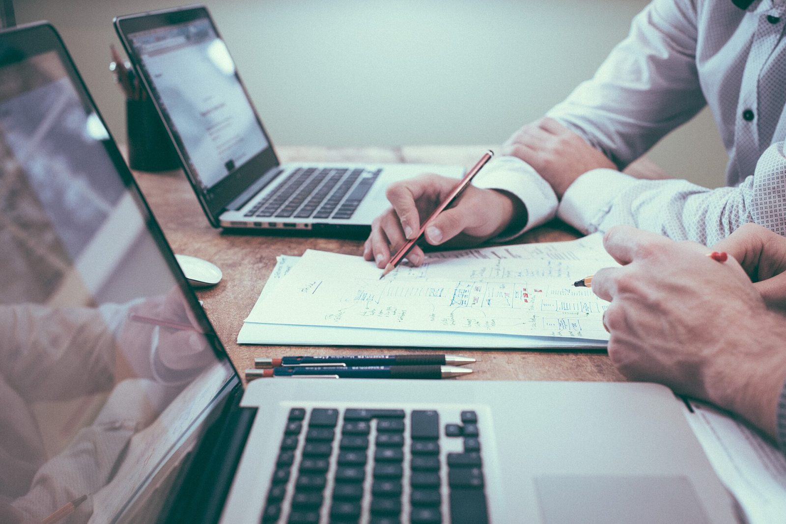 Two business advisors reviewing a strategy plan with laptops, representing AI consulting for a small business