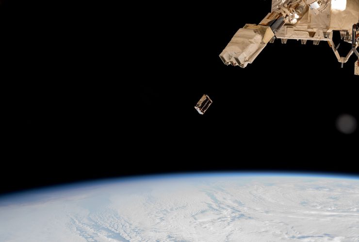 A CubeSat small satellite is ejected into Earth orbit from a deployer outside the International Space Station