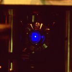 A strontium atomic clock lab setup showing a glowing blue cloud of laser-trapped atoms used to measure super-fine timing ticks